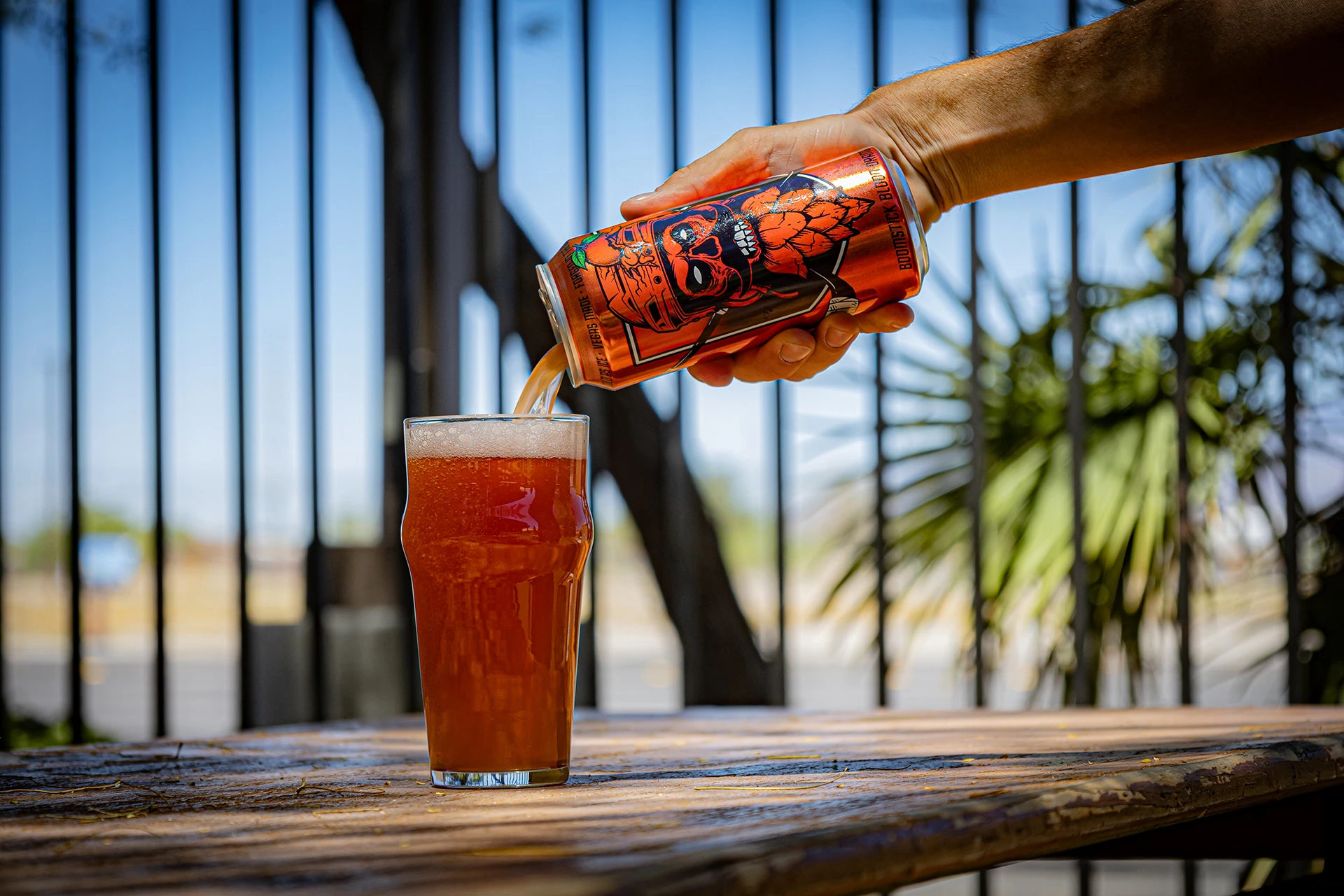 Pouring Boomstick Blood Orange into a pint on a sunlit table
